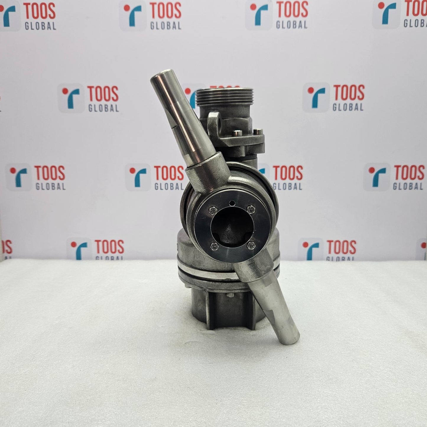 Mechanical component on a white surface with 'TOOS GLOBAL' branding in the background