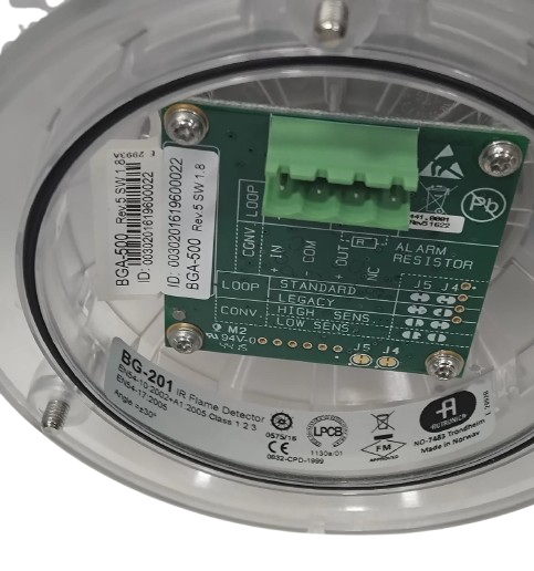 Close-up of a security system component with labels and wiring on a white background