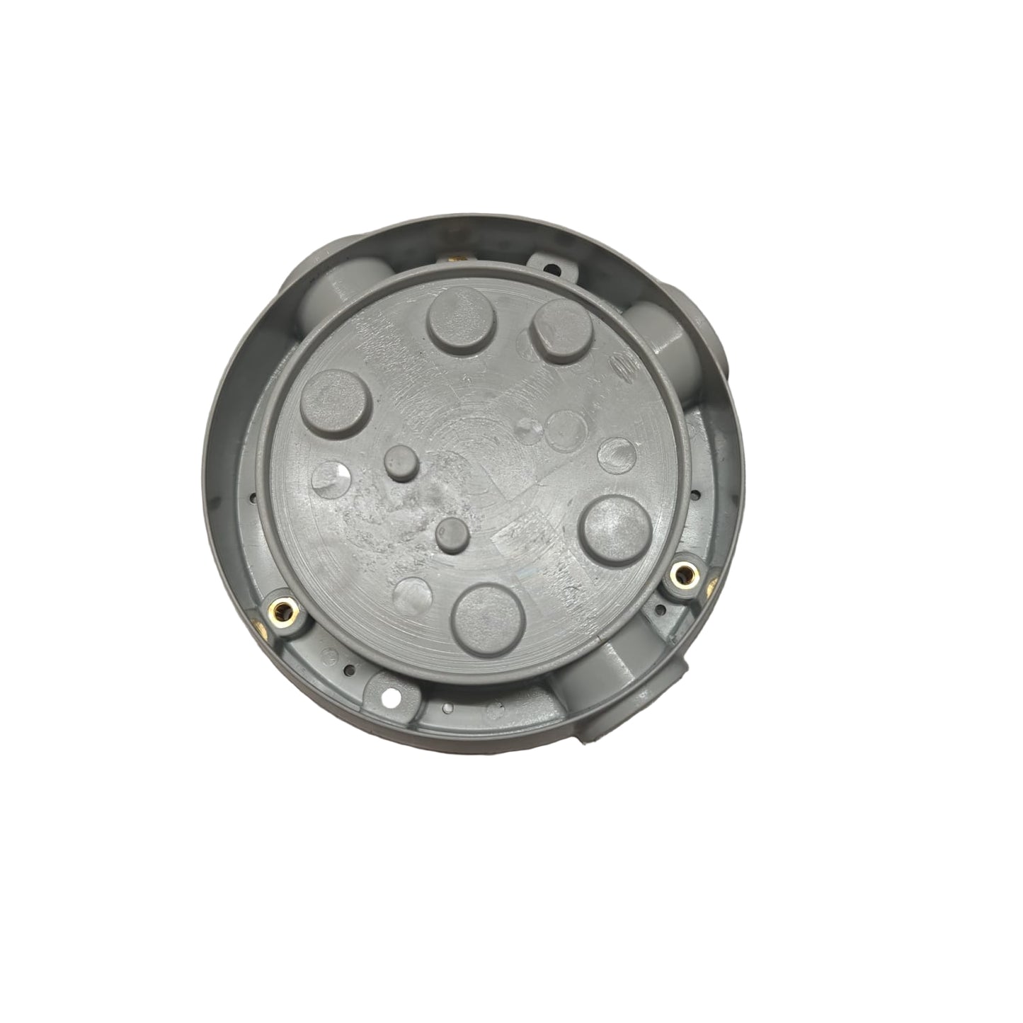 Metallic circular component on a gray surface with packaging in the background