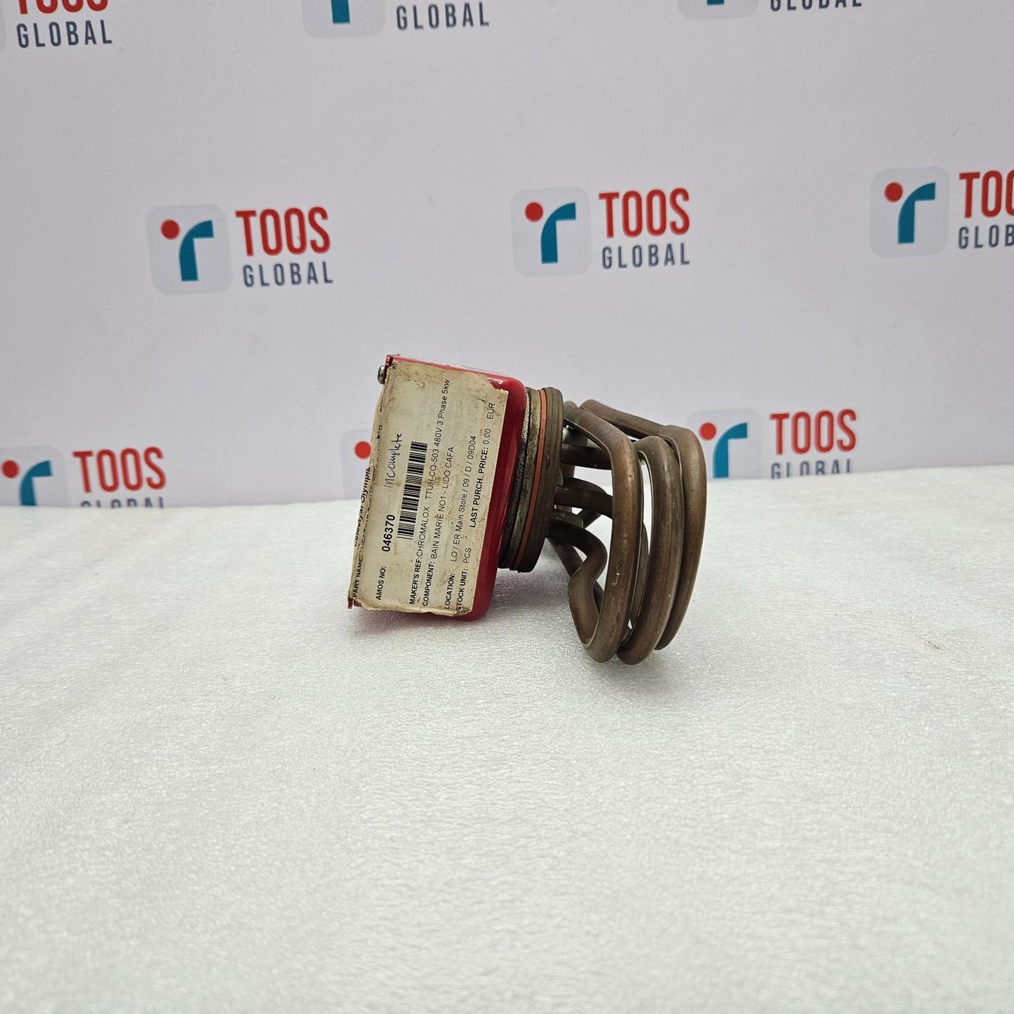 Mechanical component on a white surface with 'TOOS GLOBAL' branding in the background