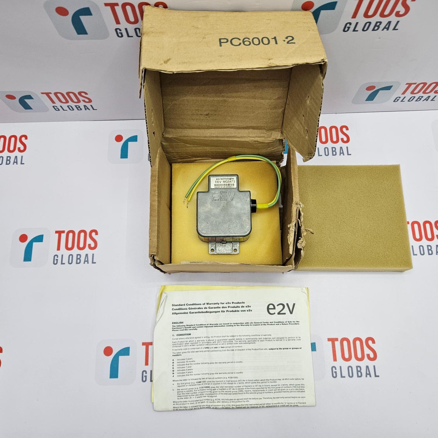 Yellow electronic component in an open cardboard box with a TOOS Global branded background