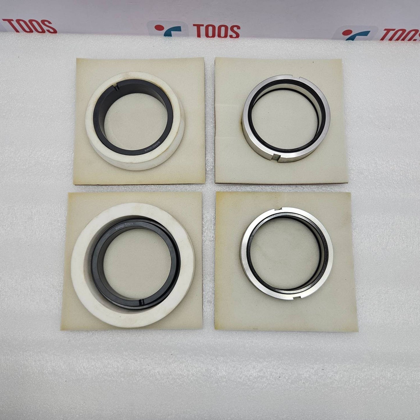 eagle burgmann Four mechanical seals on beige squares with 'TOOS' branding in the background.