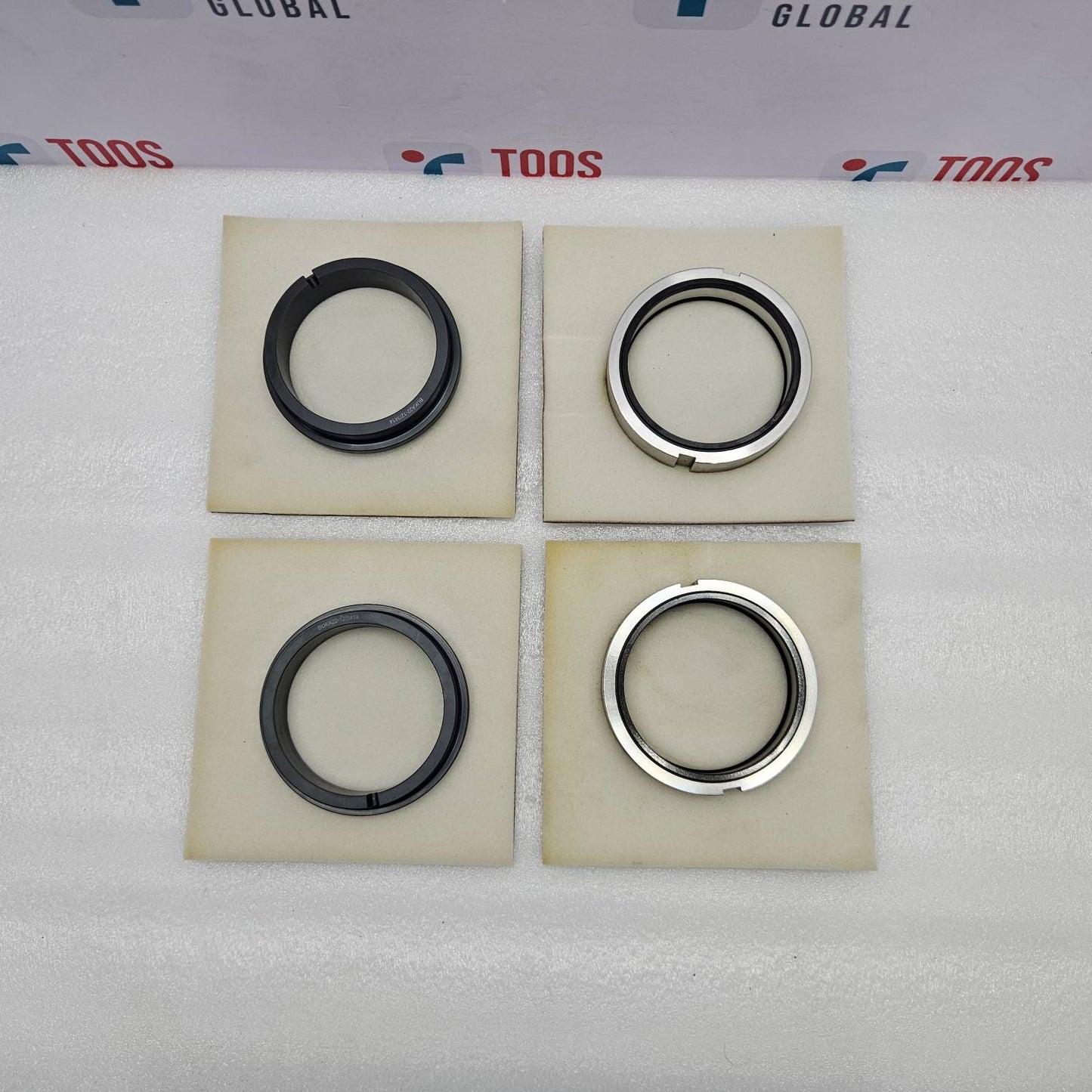 eagle burgmann Four mechanical seals on beige squares with 'TOOS' branding in the background.