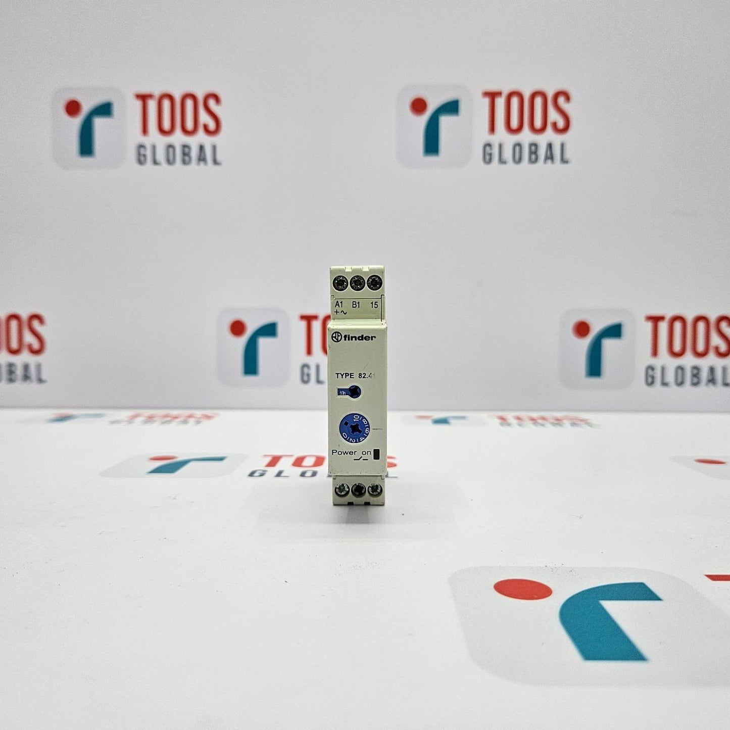 Small electronic device on a white surface with 'TOOS GLOBAL' branding in the background.