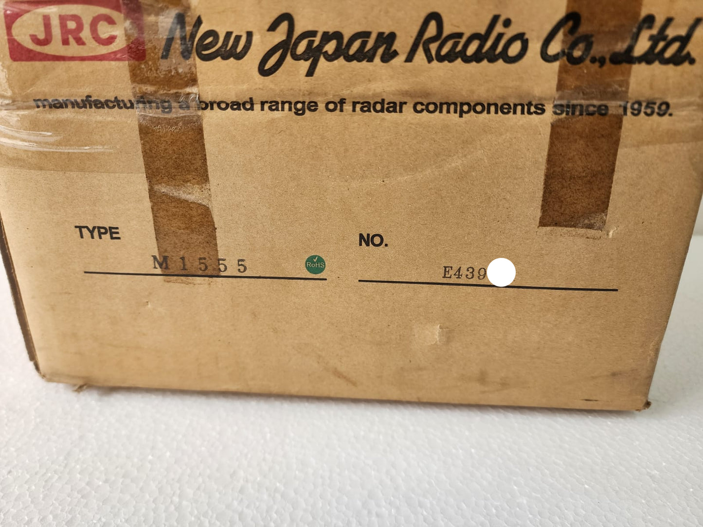 Cardboard box with 'New Japan Radio Co., Ltd.' branding and text on a white background