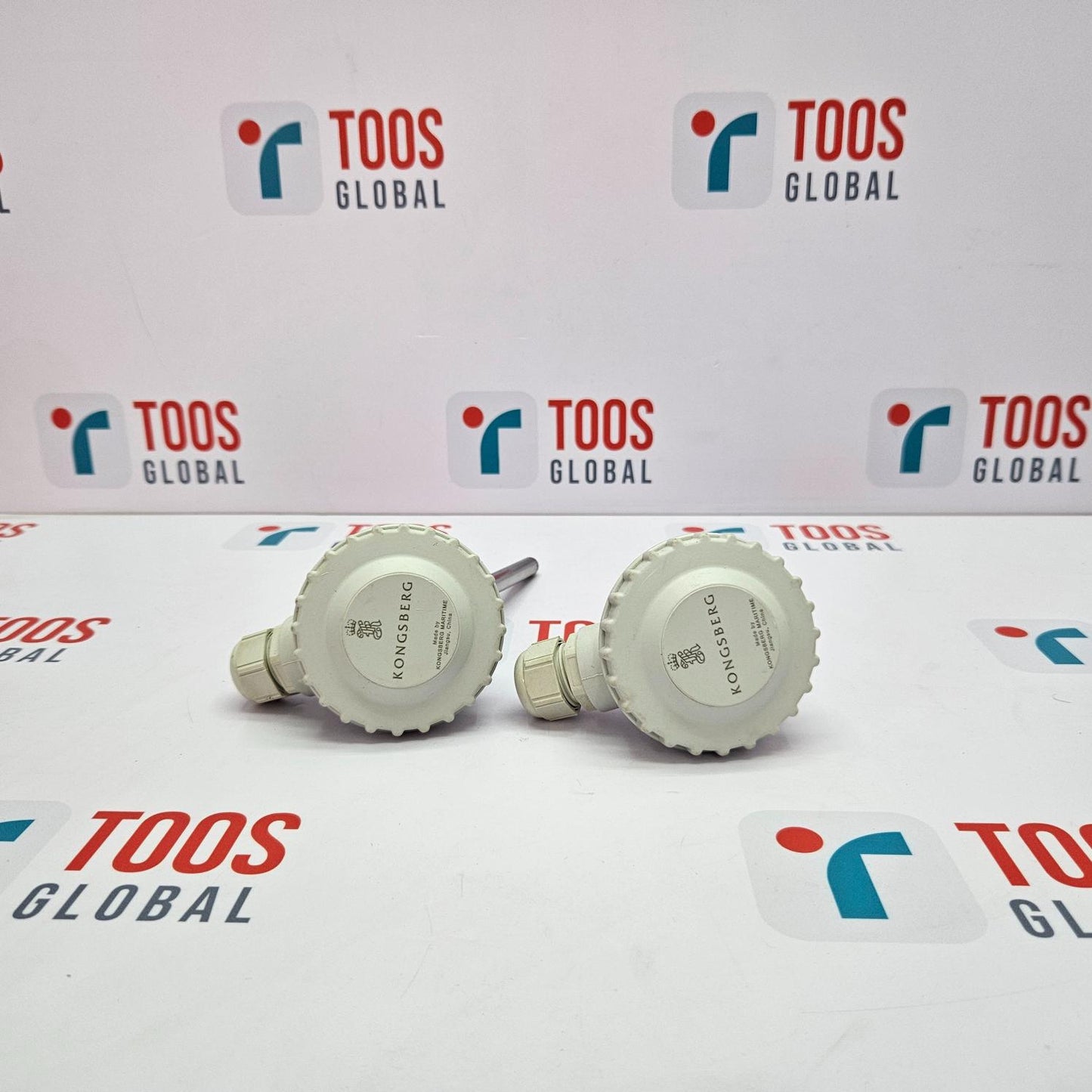 Two KONGSBERG temperature sensors placed on a surface with the brand name 'TOOS GLOBAL' displayed in the background.