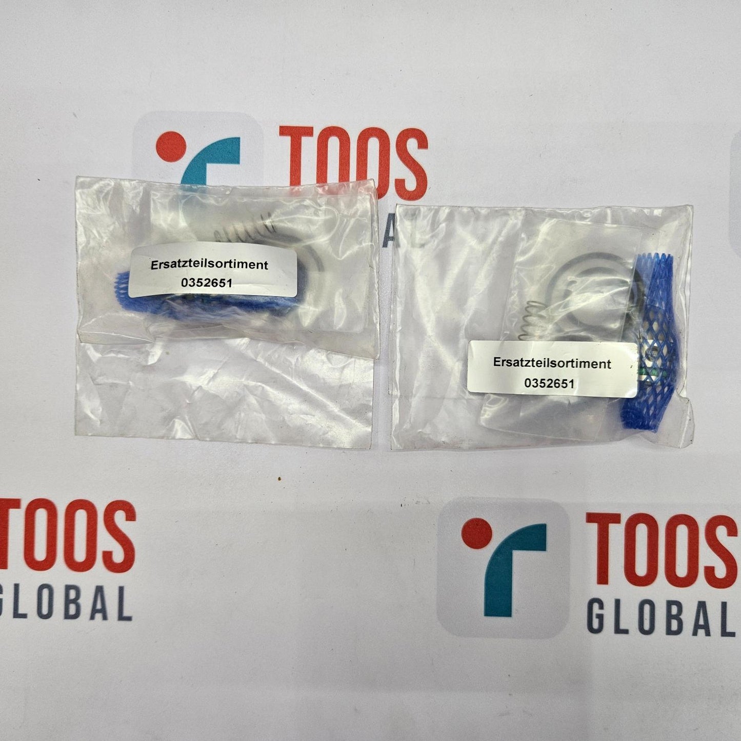 Two packages of replacement parts with labels on a TOOS Global branded background