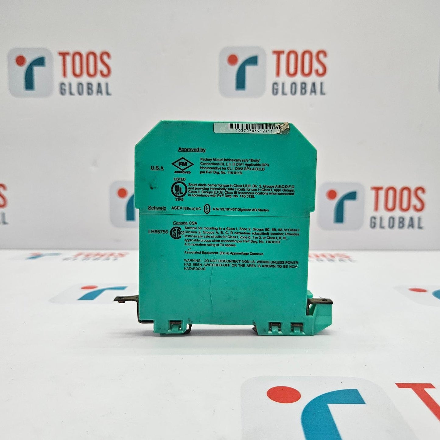 Green electronic component on a white surface with 'TOOS GLOBAL' branding in the background.