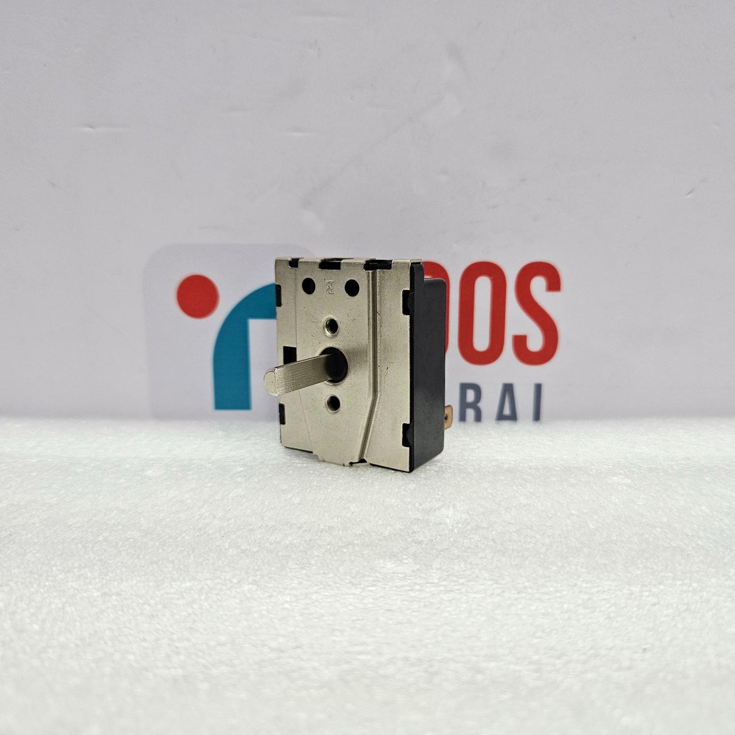 Mechanical component on a textured white surface with a blurred background featuring logos.
