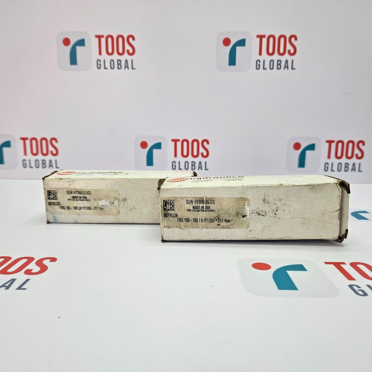 Two boxes with visible wear on a white background featuring 'TOOS GLOBAL' branding.