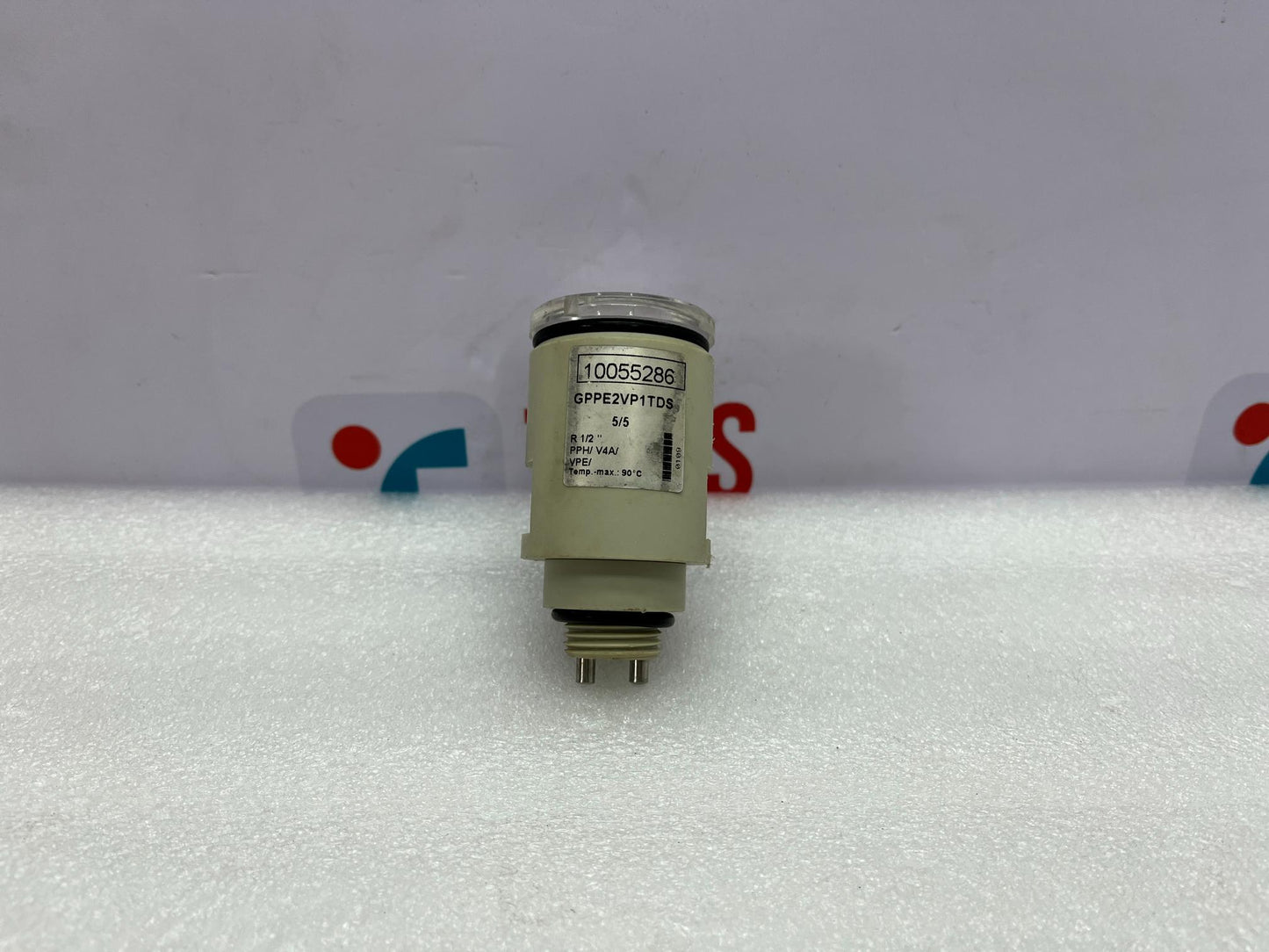 Mechanical component on a white background with a blurred logo in the background