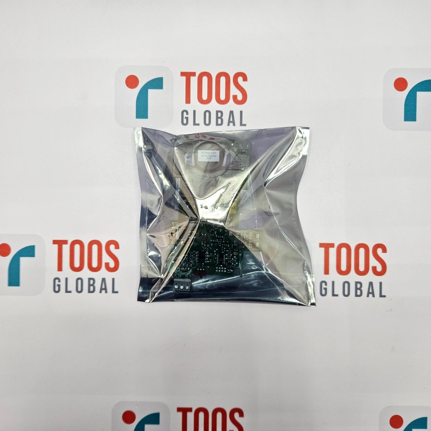Silver triangular object in a clear plastic bag with 'TOOS GLOBAL' branding on a white background.