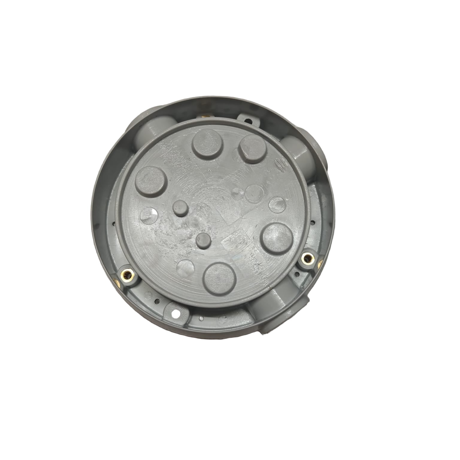Metallic circular component on a gray surface with packaging in the background