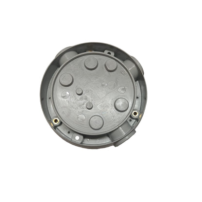Metallic circular component on a gray surface with packaging in the background