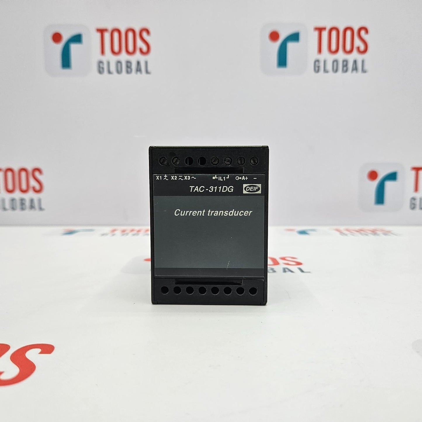 A DEIF TAC-311DG current transducer with a black casing, several connection ports, and branding on the front.