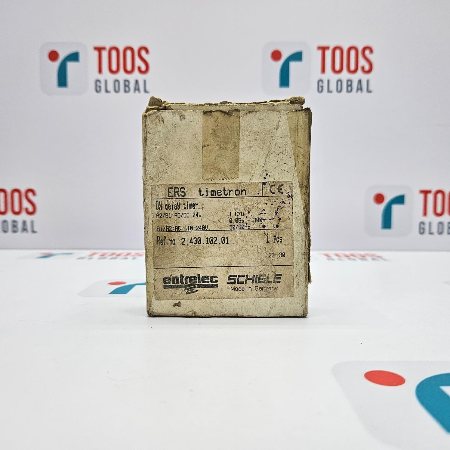 ENTRELEC SCHIELE on delay timer packaging with visible branding and model number, located in a warehouse setting with 'TOOS GLOBAL' branding in the background.