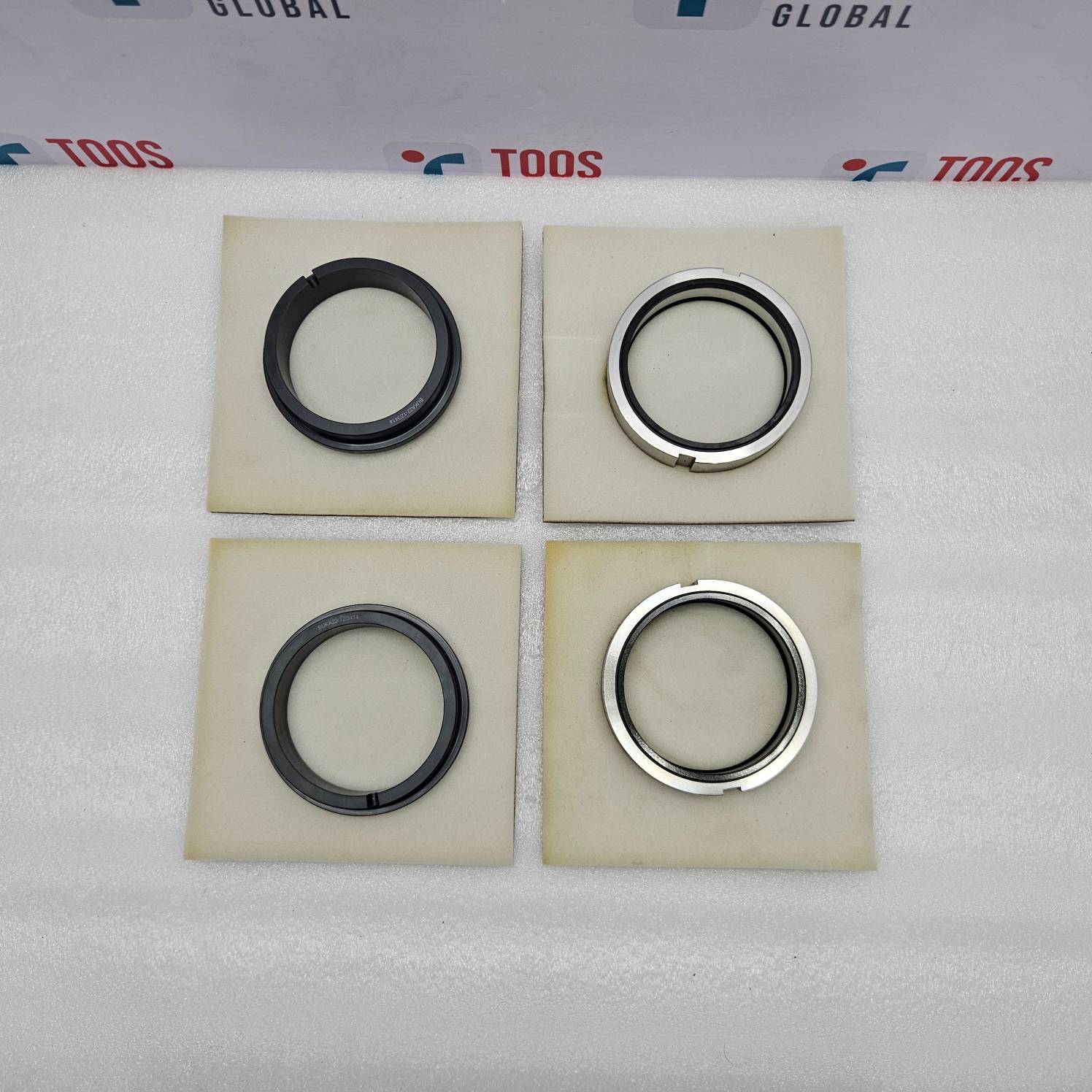 eagle burgmann Four mechanical seals on beige squares with 'TOOS' branding in the background.