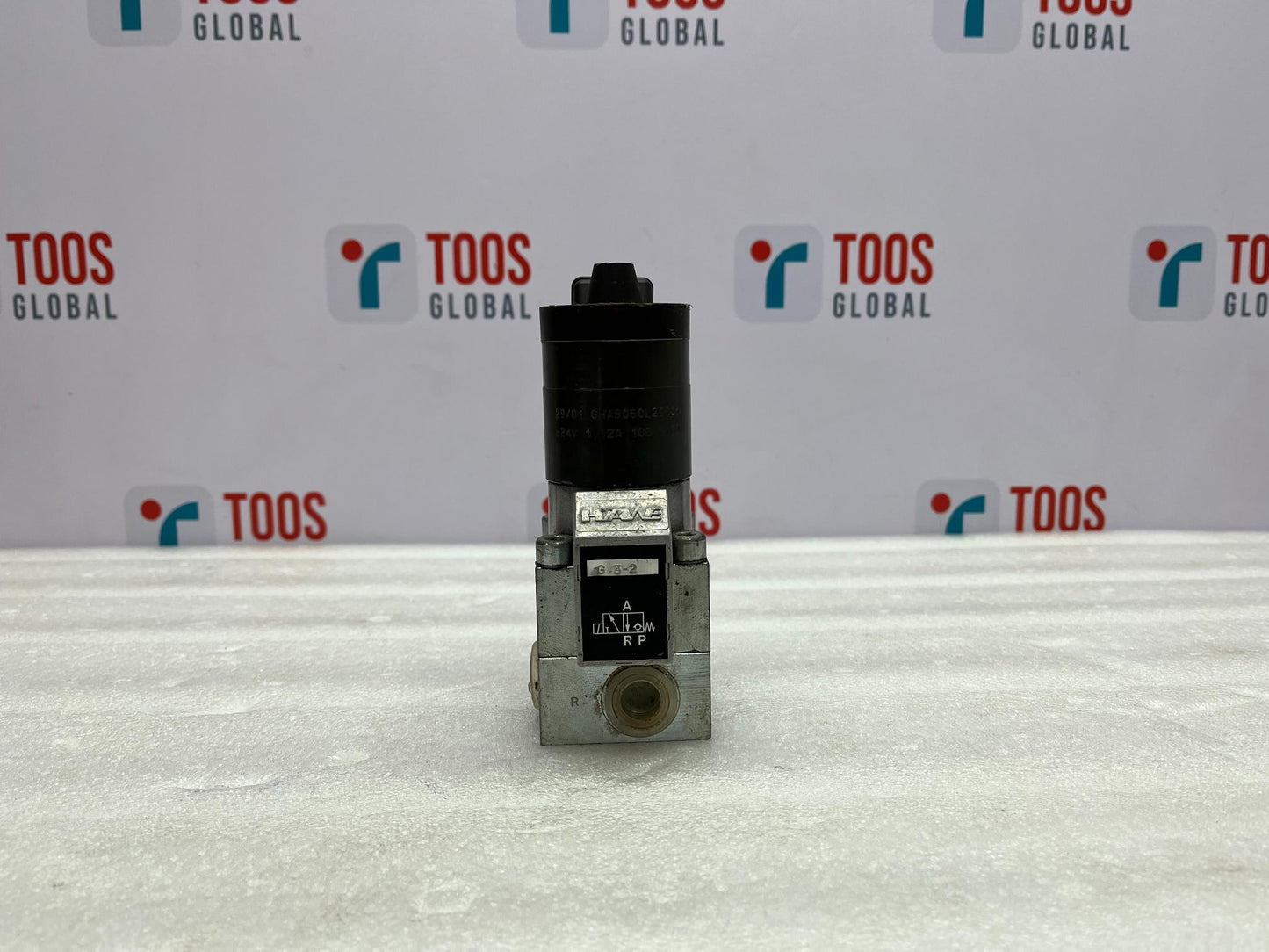 Mechanical valve on a white surface with 'TOOS GLOBAL' branding in the background.