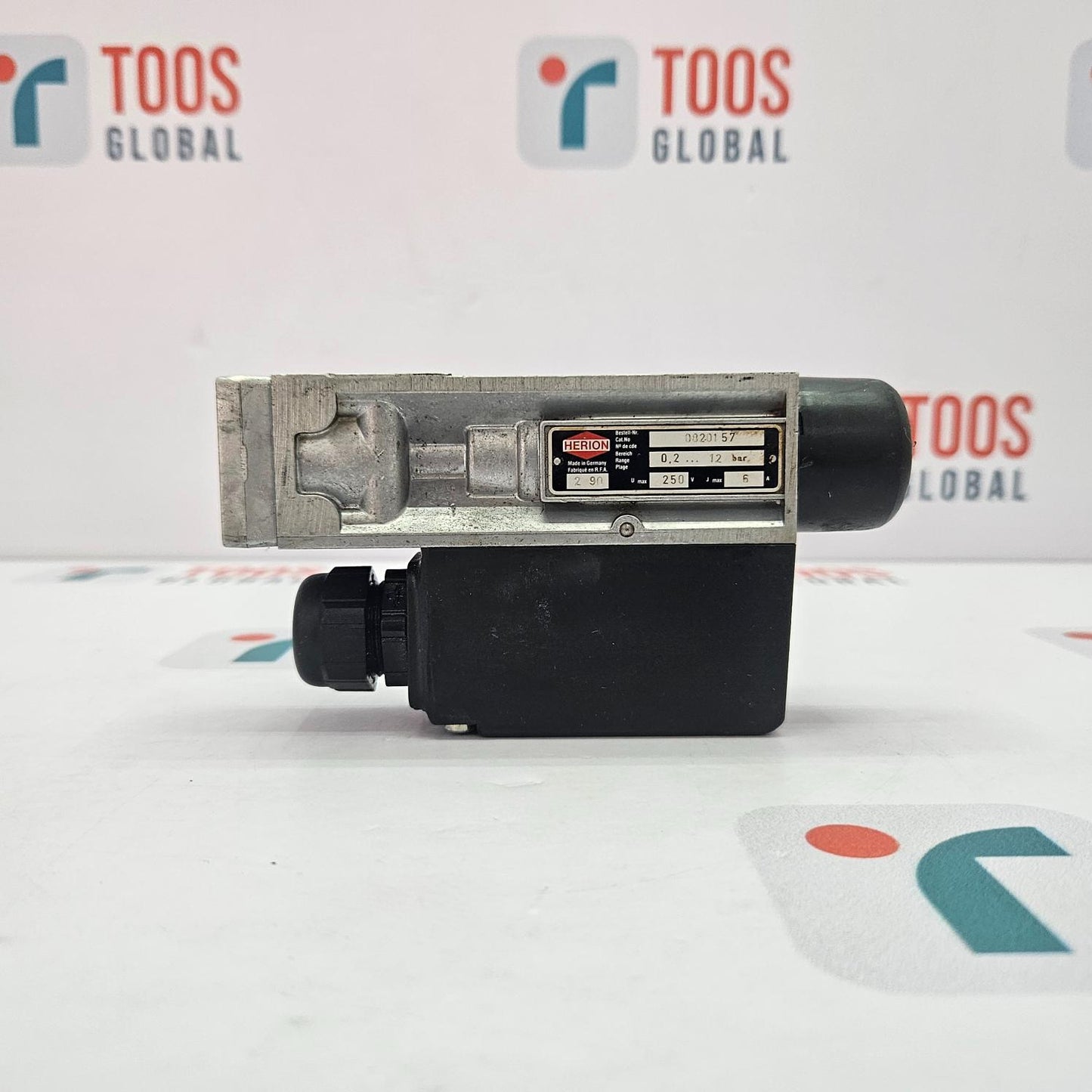 Mechanical component with 'TOOS GLOBAL' branding in the background