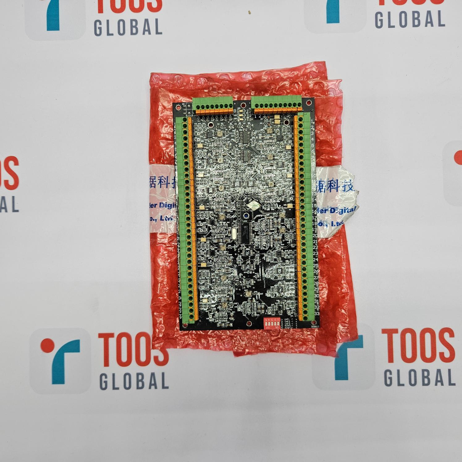 Electronic circuit board in a red plastic bag with 'TOOS GLOBAL' branding in the background.