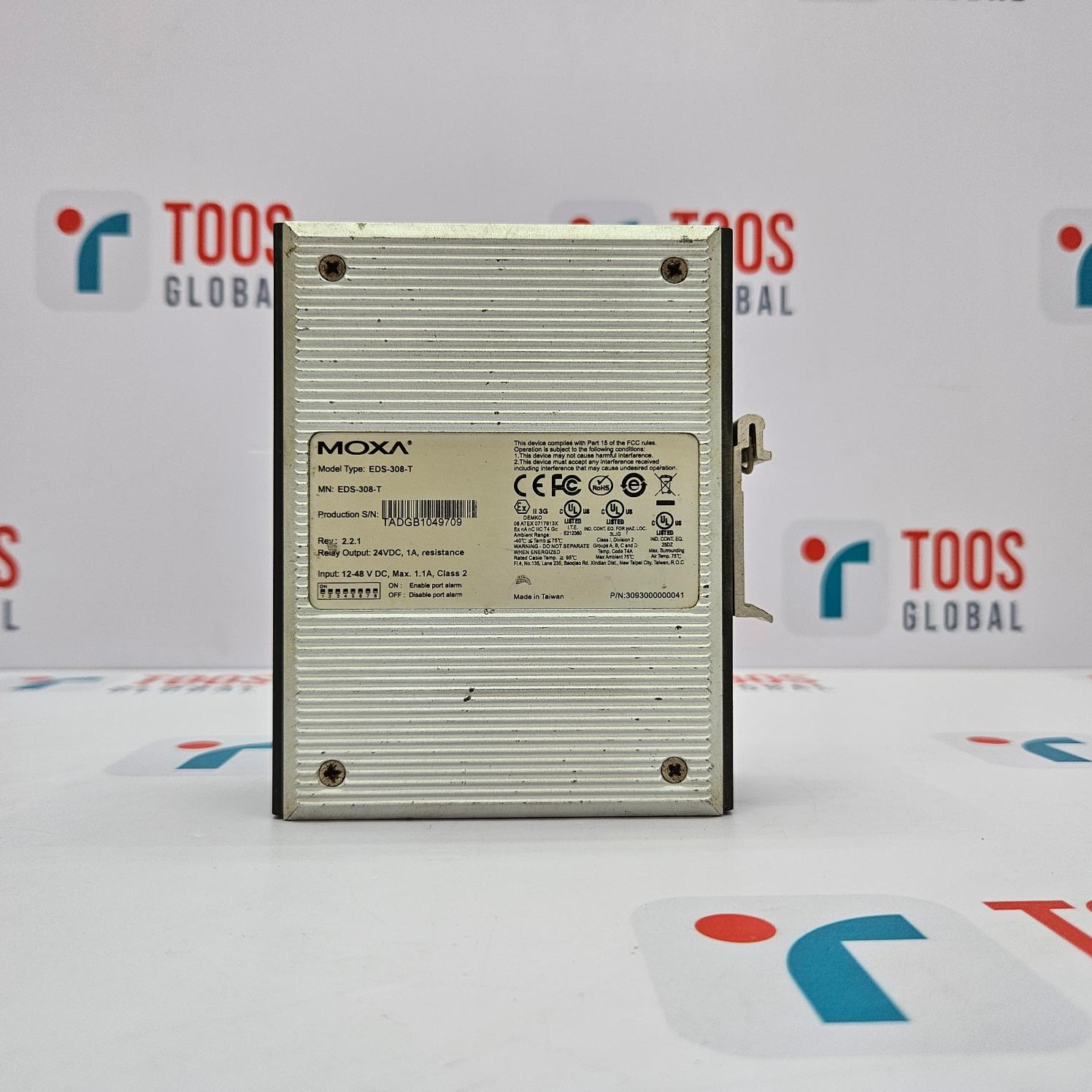 A MOXA EDS-308-T 8-PORT UNMANAGED ETHERNET SWITCH placed on a table with a TOOS GLOBAL background.