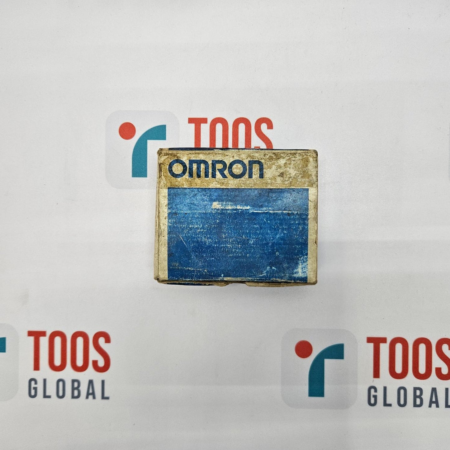 An OMRON limit switch with model number XE-Q21-2 and dimensions 25x6ra displayed on a surface with the brand logo visible in the background.