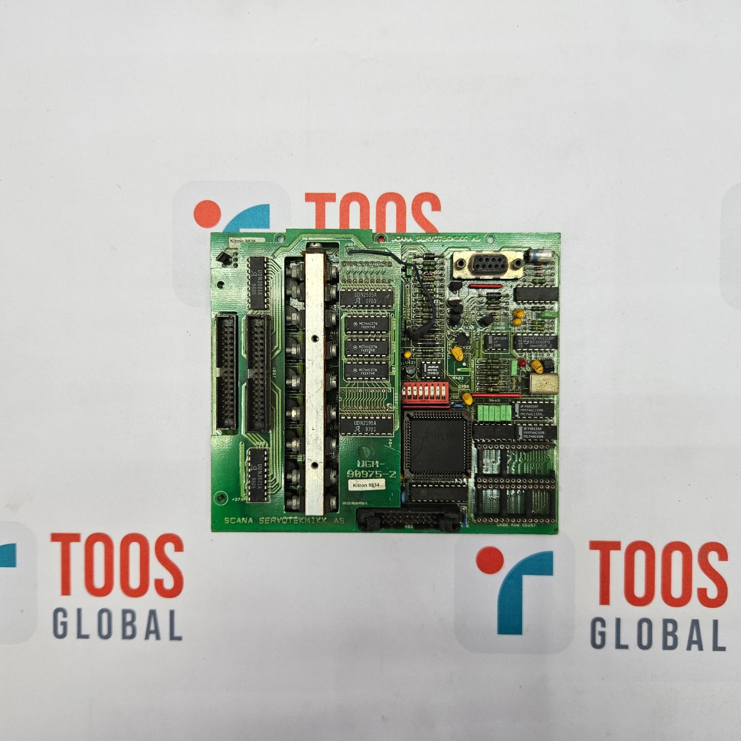 Green electronic circuit board with 'TOOS' branding on a gray background