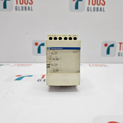 Control panel with Telemecanique branding on a white background with blurred logos.