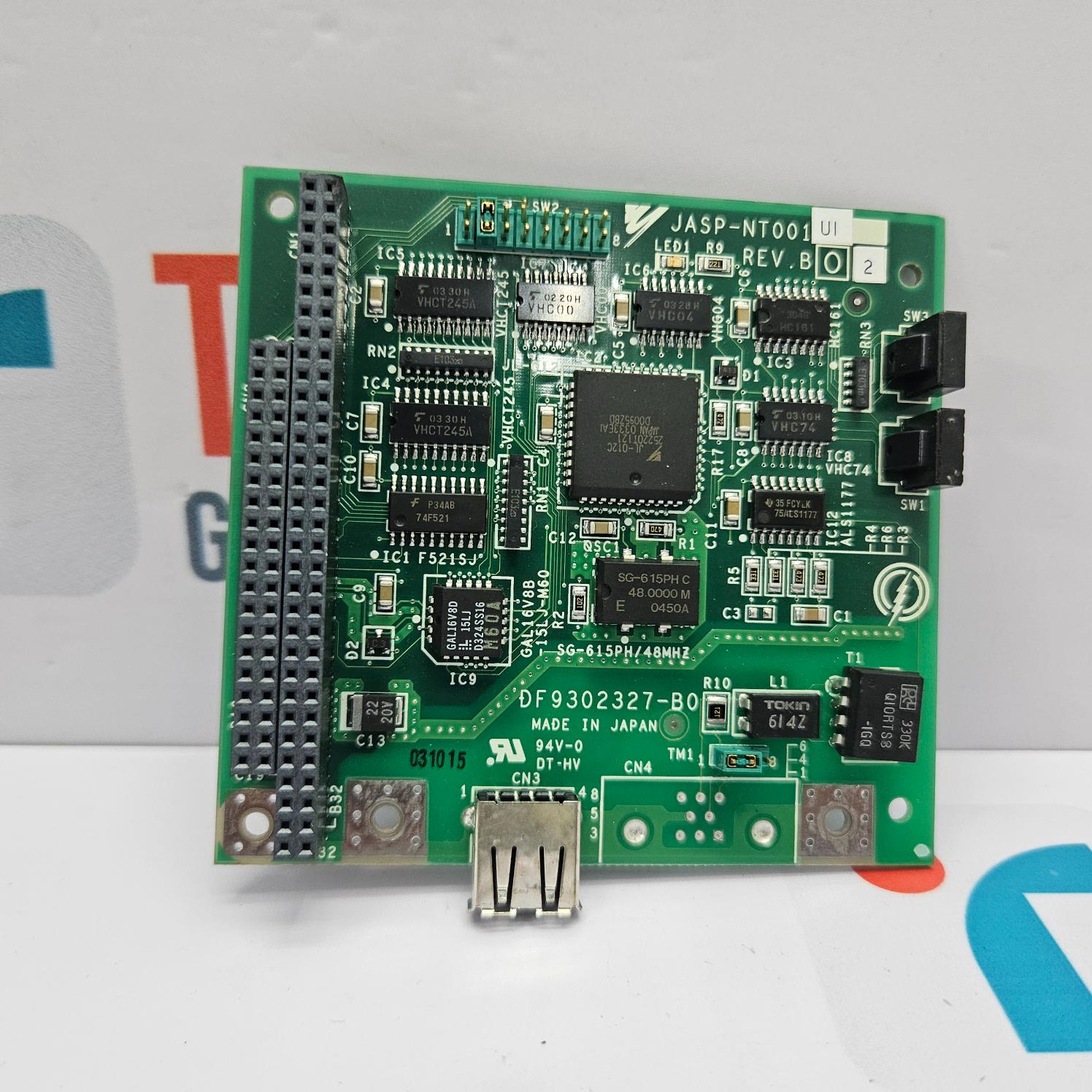 Green electronic circuit board with various components on a white background
